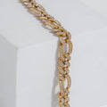 Gold chain necklace with embedded stones on a white background